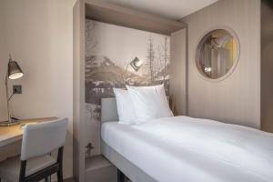 a bedroom with a bed and a desk and a mirror at Boutique Hotel St. Georg in Einsiedeln