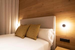 a bedroom with a white bed with two pillows at Goodnight Cádiz Apartments in Cádiz