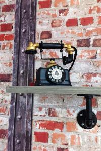 un teléfono antiguo colgado en una pared de ladrillo en Beaverhall Apartments en Edimburgo
