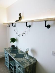 a room with a desk with a shelf on the wall at Beaverhall Holiday Apartments in Edinburgh