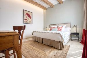 a bedroom with a bed and a desk in it at Can Alberti 1740 Boutique Hotel in Mahón
