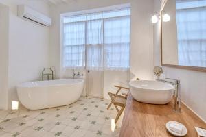 a white bathroom with a tub and a sink at Can Alberti 1740 Boutique Hotel in Mahón