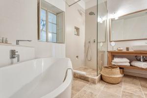 a white bathroom with a tub and a shower at Can Alberti 1740 Boutique Hotel in Mahón