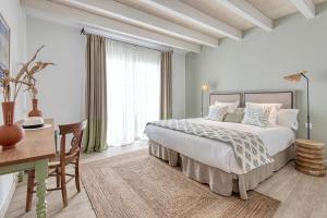 a bedroom with a bed and a desk and a table and a desk at Can Alberti 1740 Boutique Hotel in Mahón