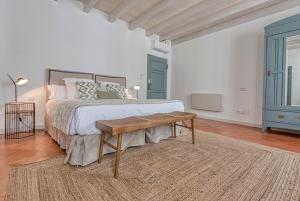 a bedroom with a bed and a wooden table at Can Alberti 1740 Boutique Hotel in Mahón