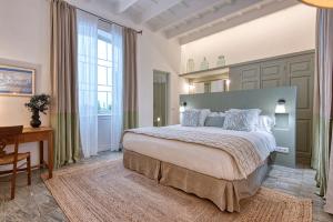 a large bedroom with a large bed and a desk at Can Alberti 1740 Boutique Hotel in Mahón