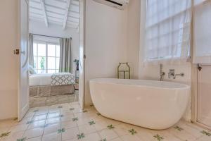 - Baño con bañera blanca y dormitorio en Can Alberti 1740 Boutique Hotel, en Mahón