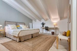 a bedroom with a large bed and a desk at Can Alberti 1740 Boutique Hotel in Mahón