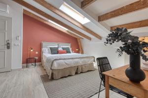 a bedroom with a bed and a table with a vase at Can Alberti 1740 Boutique Hotel in Mahón