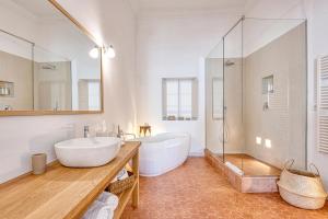 a bathroom with a large white tub and a sink at Can Alberti 1740 Boutique Hotel in Mahón