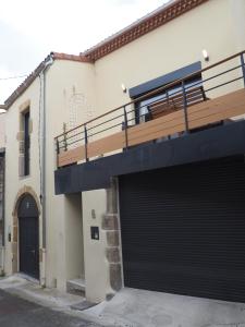 un edificio con due porte garage e un balcone di La Meïzou de Bouly a Martres-de-Veyre