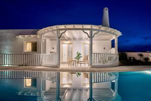 Villa con cenador sobre el agua por la noche en La Maison Private Villa, en Agia Paraskevi