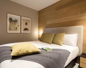 a bedroom with a bed with a book on it at Goodnight Cádiz Apartments in Cádiz
