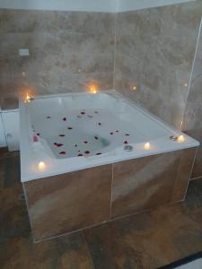 a bath tub with candles and red flowers in it at Hotel Fenix in Cúcuta
