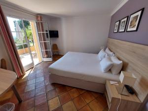 a bedroom with a large white bed and a window at Hôtel les Bouis - Vue mer in Saint-Tropez +37 photos