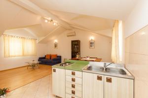 eine Küche mit einem Waschbecken und ein Wohnzimmer in der Unterkunft Holiday Home Beata in Trogir