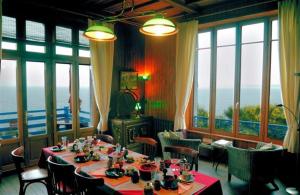 a dining room with a table and chairs and windows at Villa de Jade in Le Palais