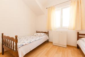 1 dormitorio con 2 camas y ventana en Holiday Home Beata, en Trogir