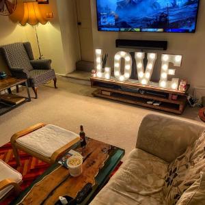 a living room with a tv with a love sign on it at The Old Court House & Jail in Menai Bridge