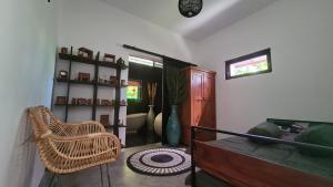 a living room with a rattan chair and a couch at King's Home Villa in Bantul
