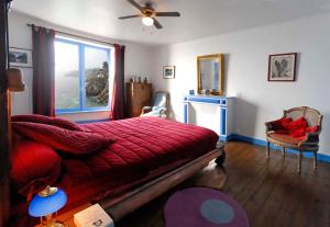 a bedroom with a red bed and a window at Villa de Jade in Le Palais