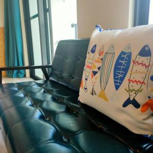 a couch with a pillow with surfboards on it at Lao Yu Homestay in Taitung City