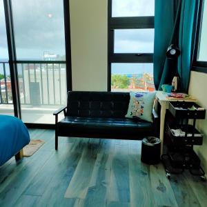 a black couch in a room with a large window at Lao Yu Homestay in Taitung City