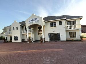 a large white building with a sign that reads hotel at Ecotel OR Tambo Airport in Kempton Park