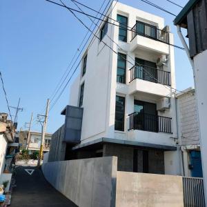 a white building with balconies on a street at Lao Yu Homestay in Taitung City