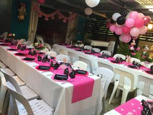 una fila di tavoli con tovaglie e palloncini rosa e bianchi di Villa chaleureuse près de Le Tampon avec piscine partagée a Le Tampon