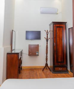 um quarto com mobiliário em madeira e uma televisão na parede em Regency inn no Cairo