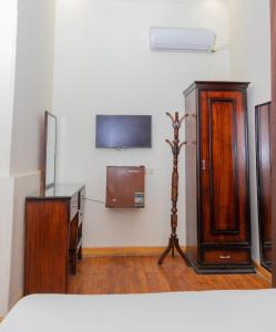 a room with wooden furniture and a tv on a wall at Regency inn in Cairo