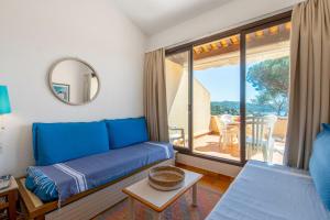 een woonkamer met een blauwe bank en een balkon bij Nice flat at 8 min walk from the beach in La Croix-Valmer - Welkeys in La Croix-Valmer