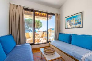een woonkamer met blauwe banken en een groot raam bij Nice flat at 8 min walk from the beach in La Croix-Valmer - Welkeys in La Croix-Valmer