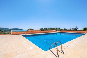 een zwembad met blauw water op een tegelvloer bij Nice flat at 8 min walk from the beach in La Croix-Valmer - Welkeys in La Croix-Valmer