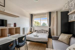 una piccola stanza con un letto e una finestra di Studio Floréal - Welkeys a Lattes