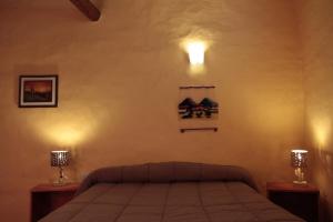 a bedroom with a bed with two lights on the wall at Hosteria La Estacion in Tilcara