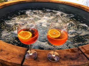 2 copas de vino frente a una bañera de hidromasaje en Baita Dal Vikingo, en Sorico