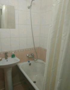 łazienka z wanną, umywalką i zasłoną prysznicową w obiekcie 3х комнатная квартира возле парка w mieście Rivne