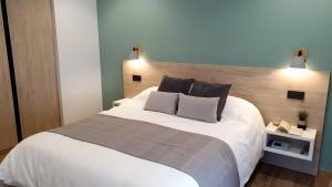 una camera da letto con un grande letto bianco con due cuscini di Hotel La Rectoral a Covelo
