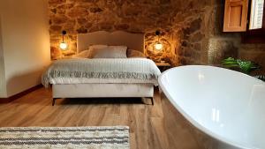 sypialnia z łóżkiem i wanną w obiekcie Hotel La Rectoral w mieście Covelo