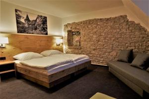 a bedroom with a bed and a stone wall at Kelterhotel Fröscher in Forchtenberg