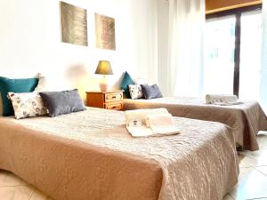 two beds in a room with two books on them at Atlântico View - Beach front - Quarteira in Quarteira