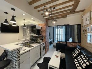 Una cocina y una sala de estar con un sofá y una mesa. en Appartement Aix, Neuf tout équipé, en París 13 fotos más