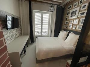 Un dormitorio con una cama y un escritorio y una ventana. en Appartement Aix, Neuf tout équipé, en París