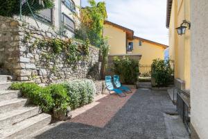 two blue chairs sitting next to a stone wall at Rose Apartment by Quokka 360 - Refined Two-Bedroom Apartment with Garden in Lugano