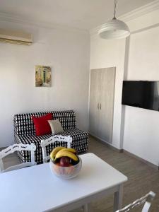 una sala de estar con sofá y un bol de fruta en una mesa en Porto, en Ermoupoli