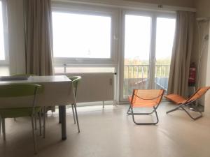 Habitación con sillas, mesa y ventanas. en Studio Heist, en Knokke-Heist