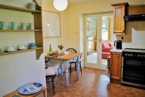 uma cozinha com uma mesa e uma sala de jantar em The Cottage Garden - A Herefordshire Retreat em Ross on Wye