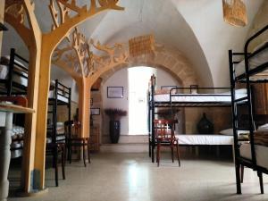 - une chambre avec des lits superposés et une chambre avec des tables et des chaises dans l'établissement Riparo di Masseria Urbana, à Crispiano